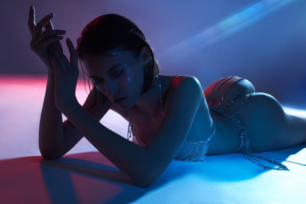 beauty-nude-massage-woman-neon-light-posing-studio